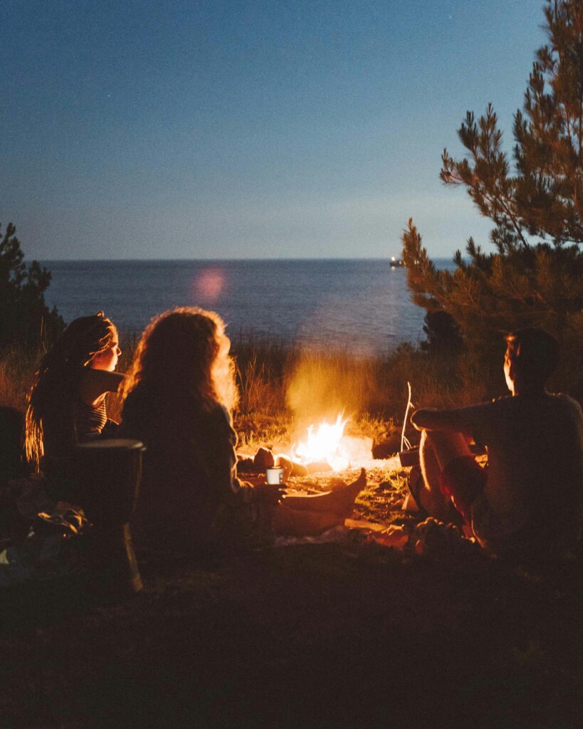 pexels-photo-9266589-9266589 Friends enjoying a campfire by the ocean at night, capturing a warm and scenic moment.